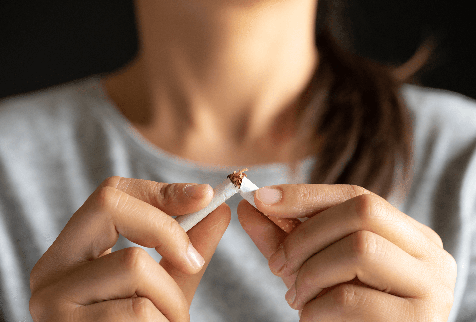lady snapping cigarette in half to quit smoking